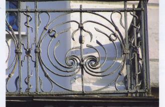 Главный фасад крыла, ориентированного вдоль Октябрьского проспекта. Балкон центрального ризалита. Фрагмент кованогоограждения.