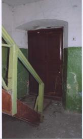 Фрагмент интерьера лестничной клетки.Дверной проем "черного" входа и лестница на 2-й этаж.