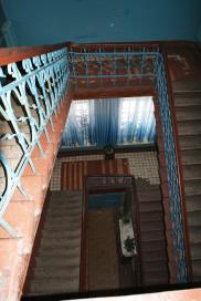 Фрагмент интерьера парадной лестничной клетки. Вид с лестничной площадки 3-го этажа на междуэтажную площадку 2-го этажа.